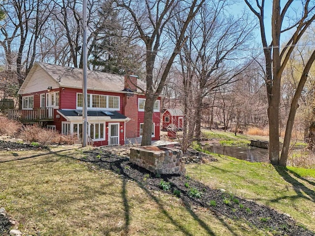 149 Oakwood Ave, Edgerton, WI 53534 - rear view of house with a chimney and a lawn