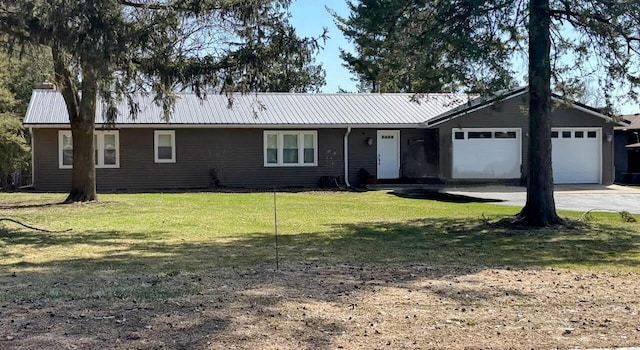 ranch-style home with driveway, a front lawn, metal roof, and an attached garage