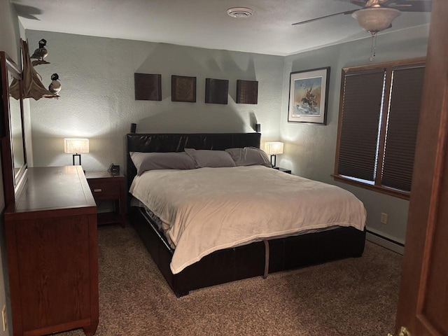 carpeted bedroom featuring a baseboard heating unit, visible vents, ceiling fan, and a textured wall