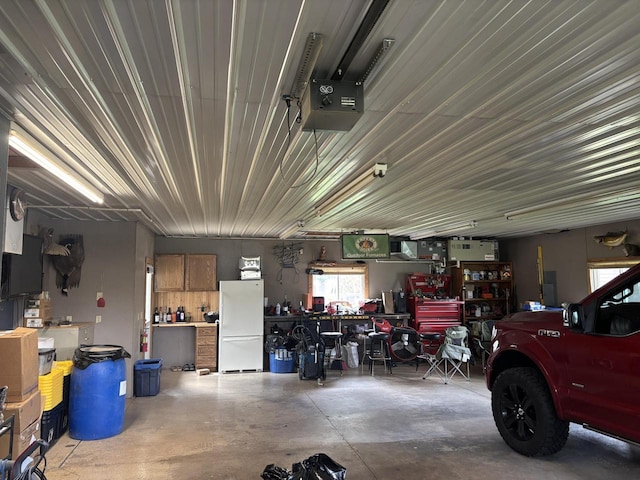 garage with a workshop area and freestanding refrigerator