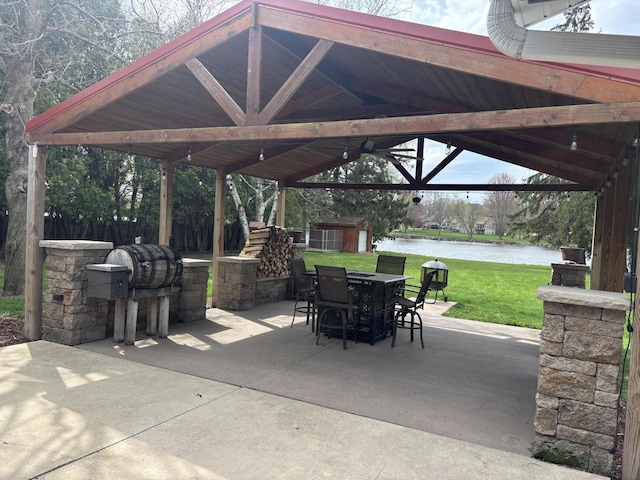 view of patio featuring outdoor dining area, an outdoor structure, a water view, a storage shed, and a gazebo