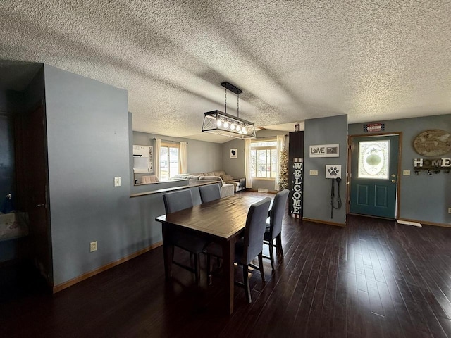 1411 Jennifer Ave, Tomah, WI 54660 - dining space featuring a textured ceiling, dark wood-style flooring, and baseboards