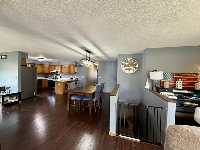 1411 Jennifer Ave, Tomah, WI 54660 - dining room featuring a textured ceiling and dark wood finished floors