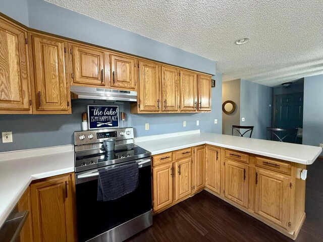 1411 Jennifer Ave, Tomah, WI 54660 - kitchen featuring a peninsula, a textured ceiling, stainless steel range with electric stovetop, under cabinet range hood, and dark wood-type flooring