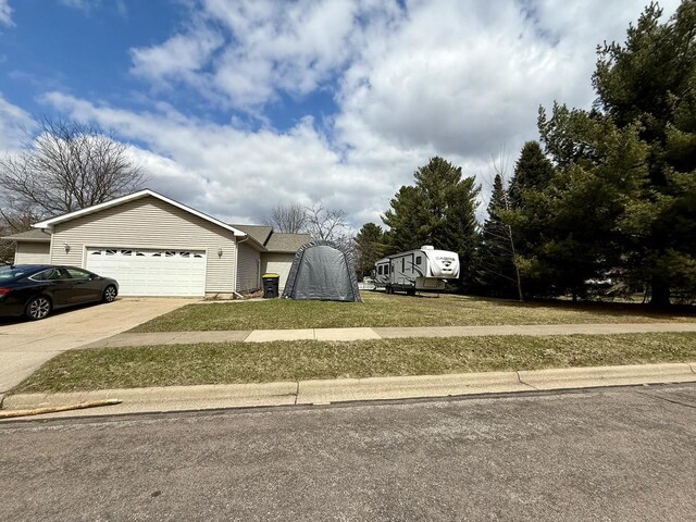 1411 Jennifer Ave, Tomah, WI 54660 - view of property exterior featuring an attached garage, concrete driveway, and a lawn