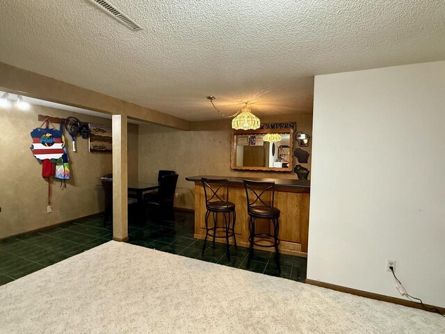 1411 Jennifer Ave, Tomah, WI 54660 - bar with visible vents, a bar, dark tile patterned flooring, and a textured ceiling
