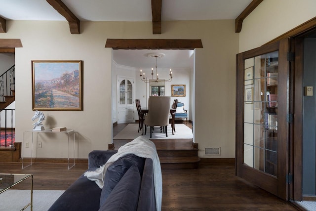 living room with visible vents, wood finished floors, stairway, beamed ceiling, and an inviting chandelier