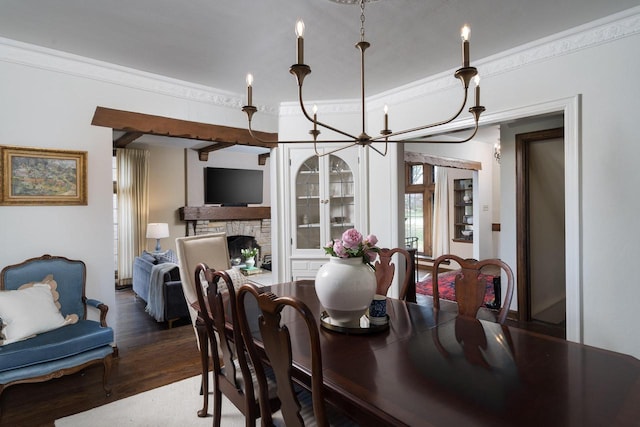 dining area featuring crown molding, a stone fireplace, and wood finished floors
