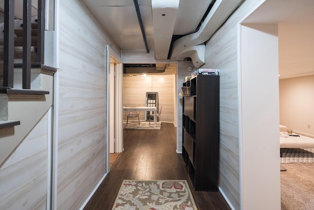 hallway featuring stairway, wood walls, and dark wood-style floors
