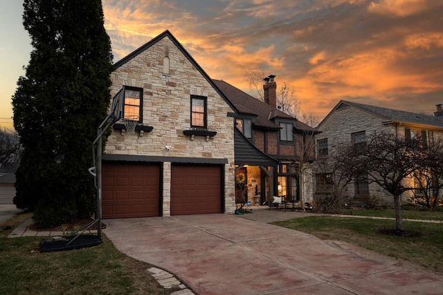 view of front facade featuring a chimney, a garage, stone siding, and concrete driveway