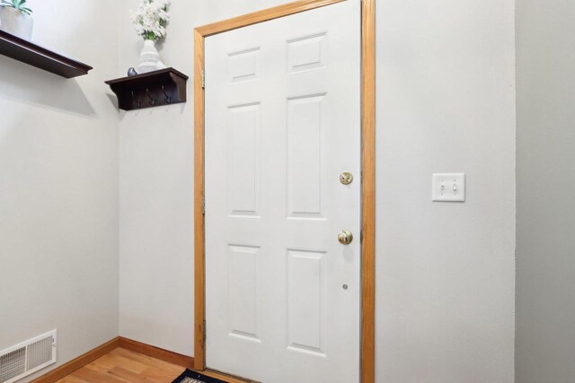 doorway featuring visible vents, baseboards, and light wood-type flooring