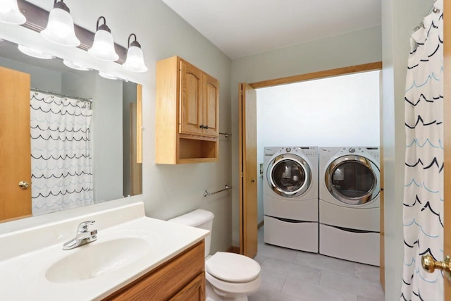 bathroom featuring toilet, washer and clothes dryer, tile patterned flooring, and vanity