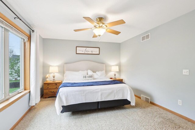 carpeted bedroom with baseboards, multiple windows, and visible vents