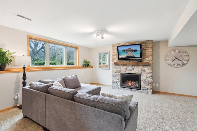carpeted living area featuring baseboards, visible vents, and a stone fireplace