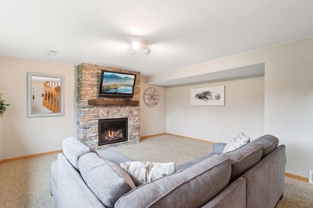carpeted living area featuring baseboards, visible vents, and a stone fireplace