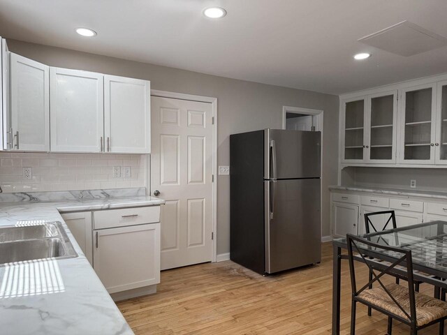4813 N 36th St, Milwaukee, WI 53209 - kitchen with freestanding refrigerator, a sink, white cabinetry, and glass insert cabinets