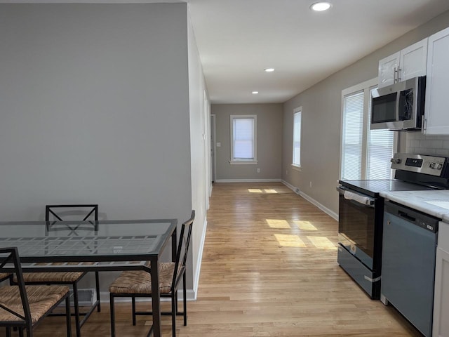4813 N 36th St, Milwaukee, WI 53209 - kitchen featuring recessed lighting, light wood-style floors, decorative backsplash, and appliances with stainless steel finishes