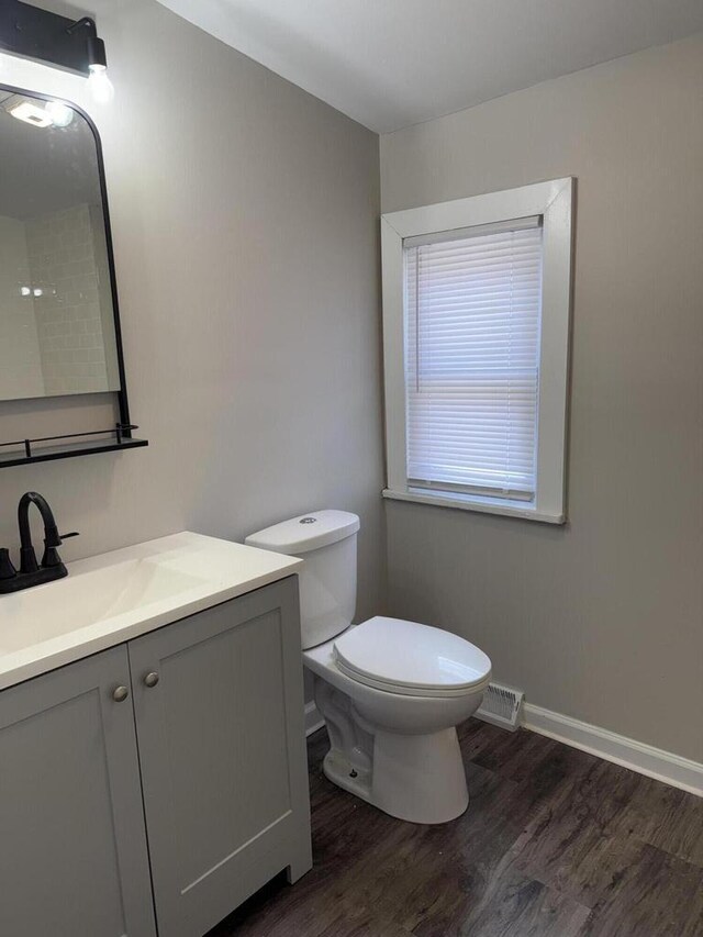 4813 N 36th St, Milwaukee, WI 53209 - bathroom featuring vanity, baseboards, toilet, visible vents, and wood finished floors