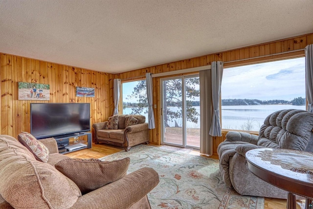 10439 W County Highway D, Exeland, WI 54835 - living room with a water view, wooden walls, a textured ceiling, and wood finished floors
