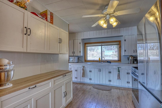 10439 W County Highway D, Exeland, WI 54835 - kitchen featuring a sink, ceiling fan, appliances with stainless steel finishes, butcher block counters, and light wood finished floors