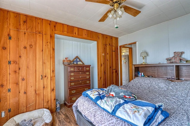 10439 W County Highway D, Exeland, WI 54835 - bedroom with wood finished floors, wood walls, and a ceiling fan