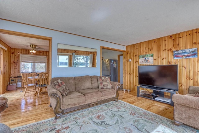 10439 W County Highway D, Exeland, WI 54835 - living room featuring wood walls, a ceiling fan, and wood finished floors