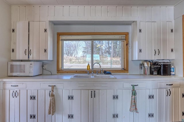 10439 W County Highway D, Exeland, WI 54835 - kitchen featuring white cabinets, white microwave, light countertops, and a sink