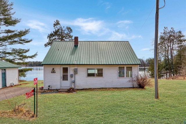 10439 W County Highway D, Exeland, WI 54835 - view of front of home featuring a front yard, metal roof, a water view, and a chimney