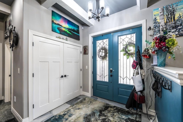 foyer with baseboards and an inviting chandelier