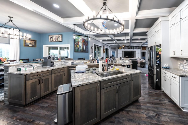 kitchen with a large island, a notable chandelier, a sink, open floor plan, and freestanding refrigerator