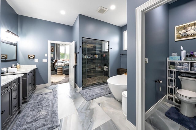 full bathroom with a shower stall, vanity, toilet, a freestanding bath, and baseboards
