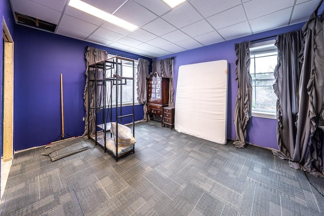 carpeted empty room with a paneled ceiling