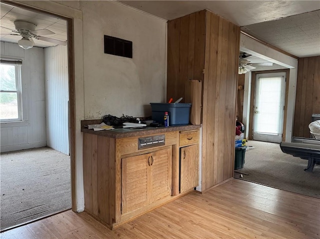 3168 W Howard St, Winter, WI 54896 - kitchen featuring visible vents, wooden walls, a ceiling fan, and plenty of natural light