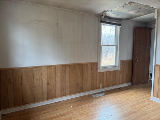 3168 W Howard St, Winter, WI 54896 - spare room featuring wood walls, hardwood / wood-style flooring, and a wainscoted wall