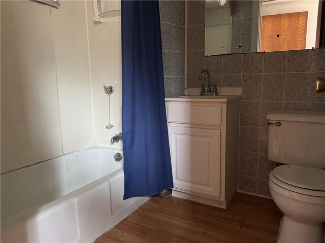 3168 W Howard St, Winter, WI 54896 - full bath with toilet, wood finished floors, shower / bath combination with curtain, and tile walls