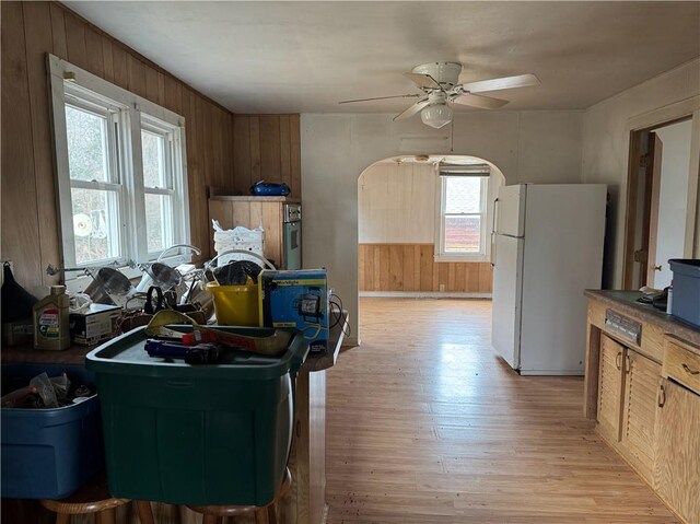 3168 W Howard St, Winter, WI 54896 - kitchen with wooden walls, light wood-type flooring, freestanding refrigerator, and ceiling fan