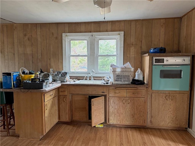 3168 W Howard St, Winter, WI 54896 - kitchen with wood walls, a sink, light wood-type flooring, and oven