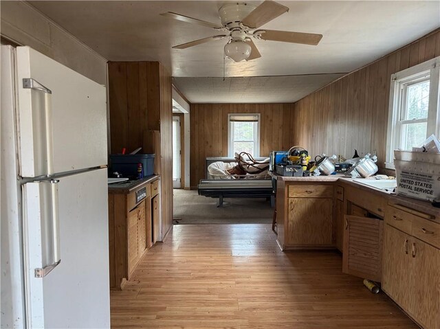 3168 W Howard St, Winter, WI 54896 - kitchen with freestanding refrigerator, a ceiling fan, a peninsula, wooden walls, and light wood-style flooring