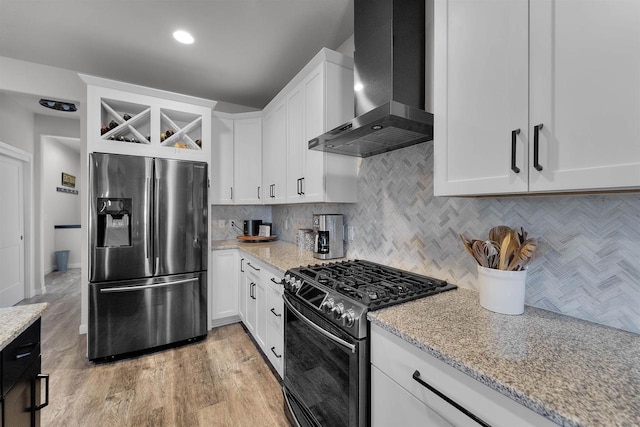 3247 Prospect Dr, Sun Prairie, WI 53590 - kitchen featuring light stone counters, decorative backsplash, white cabinets, stainless steel appliances, and wall chimney exhaust hood