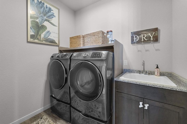 3247 Prospect Dr, Sun Prairie, WI 53590 - clothes washing area with wood finished floors, cabinet space, a sink, baseboards, and washing machine and dryer
