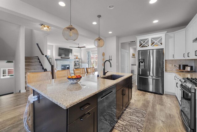 3247 Prospect Dr, Sun Prairie, WI 53590 - kitchen featuring stainless steel fridge, black gas stove, light wood finished floors, a sink, and dishwashing machine