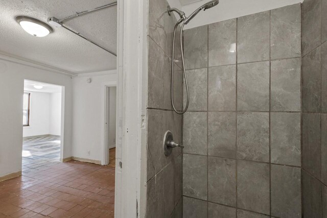 full bath featuring a tile shower and a textured ceiling