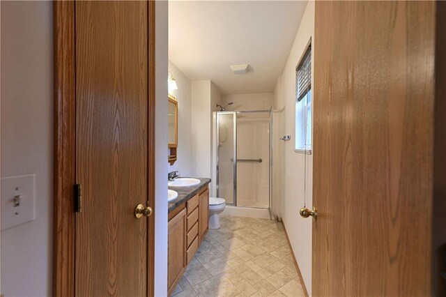 bathroom with a shower stall, tile patterned flooring, vanity, and toilet