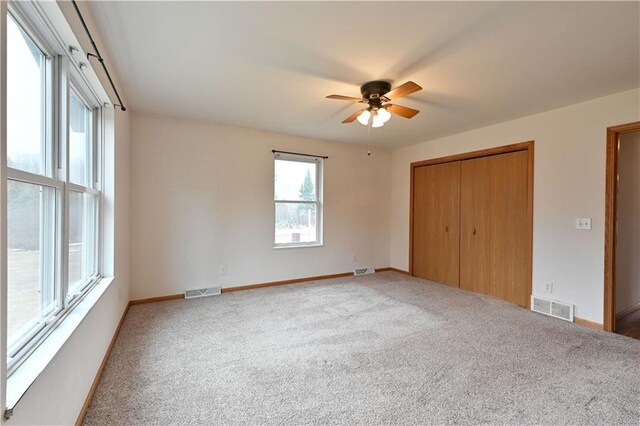 unfurnished bedroom with a closet, baseboards, carpet, and visible vents