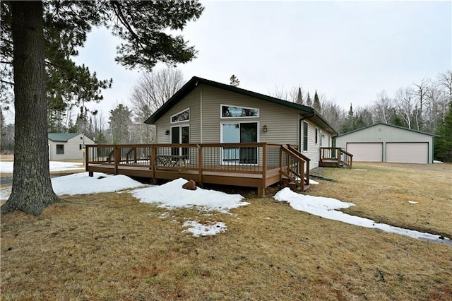 rear view of property with a deck, an outbuilding, and a detached garage