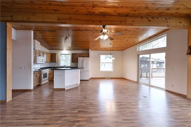 kitchen with visible vents, a wealth of natural light, dark countertops, and white appliances