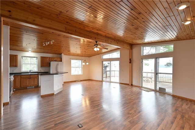 unfurnished living room with a wealth of natural light, wood ceiling, wood finished floors, and ceiling fan