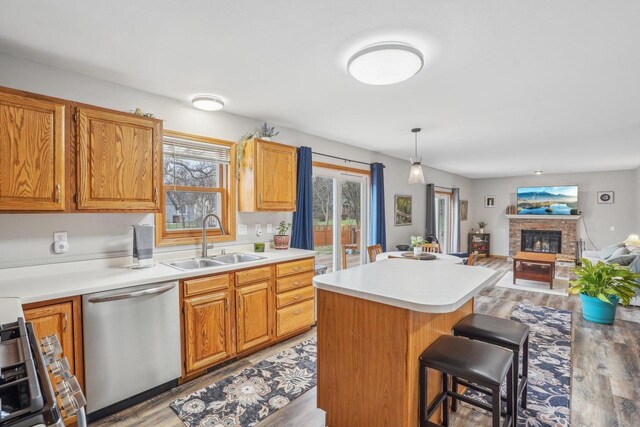 7817 Brule St, Madison, WI 53717 - kitchen with light wood-style flooring, a breakfast bar, appliances with stainless steel finishes, a sink, and light countertops