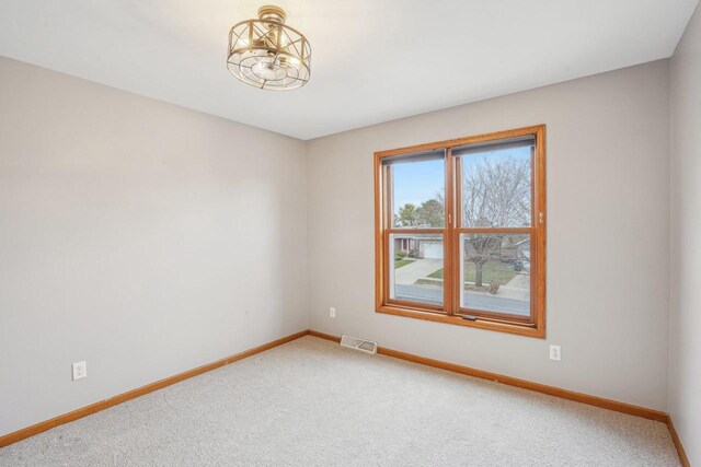 7817 Brule St, Madison, WI 53717 - unfurnished room with carpet, visible vents, baseboards, and an inviting chandelier