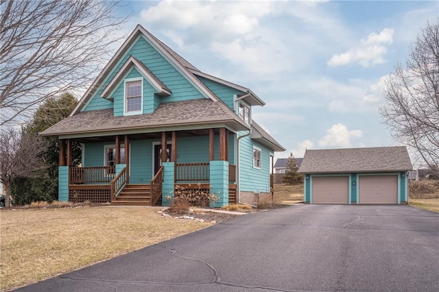 318 Meadow Lark Ln, Osceola, WI 54020 - view of front facade with a shingled roof, a detached garage, covered porch, an outbuilding, and a front lawn